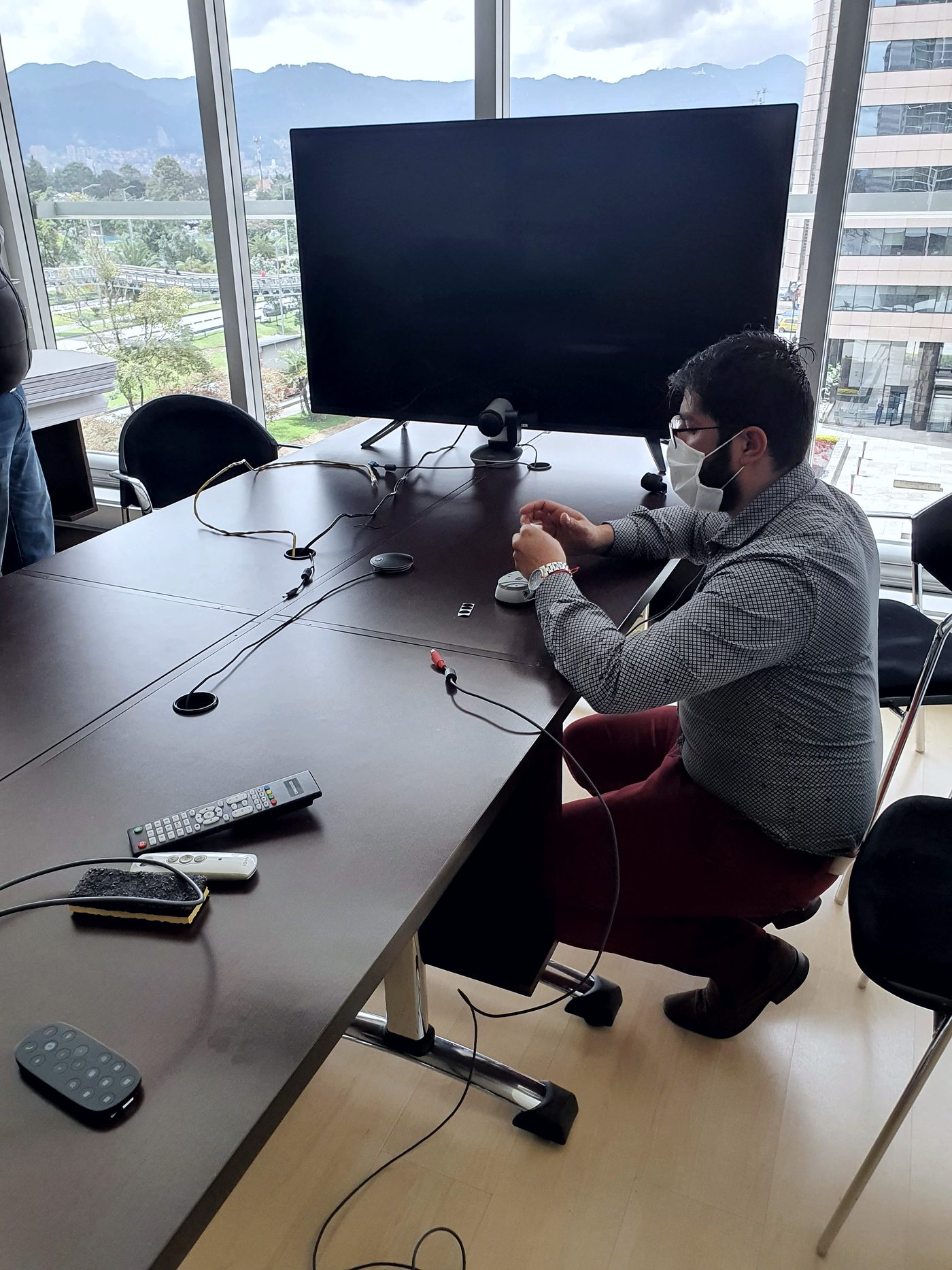 Técnico de INNCET configurando una sala de reuniones con videoconferencia