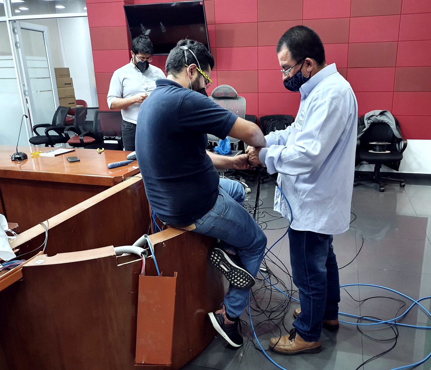 Técnicos de INNCET conectando el sistema de audio de una sala de juntas institucional