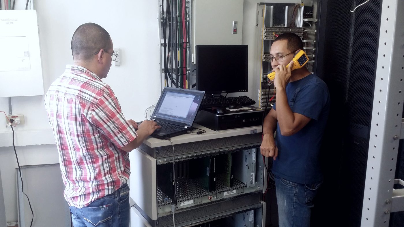 Técnicos de INNCET haciendo pruebas de telefonía en un cuarto de comunicaciones